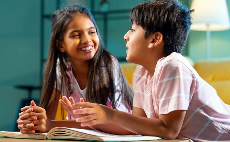 Two primary-school students discussing a book together